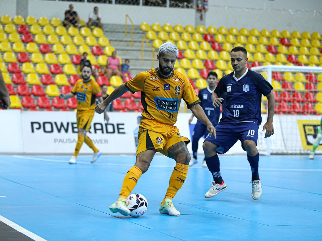 Jogador do Magnus conduz a bola sob marcação de atleta do adversário, em jogo da LNF Cresol