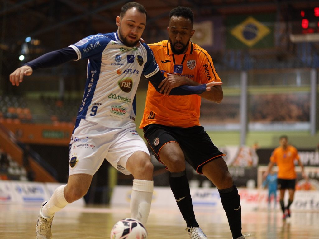 Jogador da ACBF disputa a bola com atleta adversário, em jogo da LNF Cresol