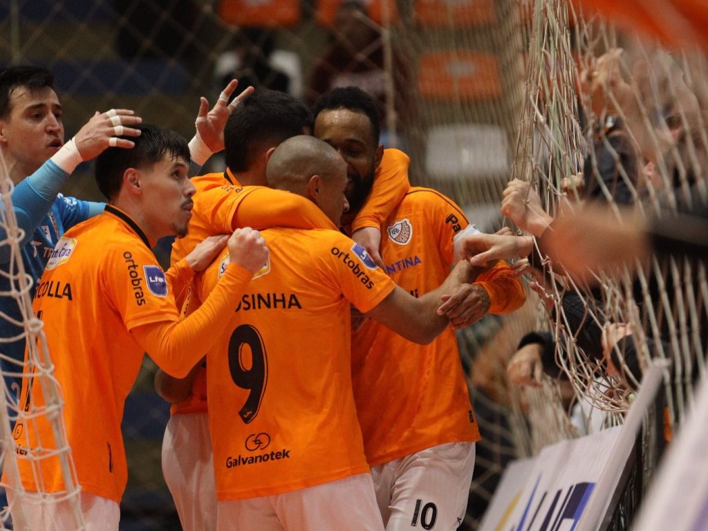 Jogadores da ACBF comemoram juntos junto ao alambrado, em jogo da LNF Cresol